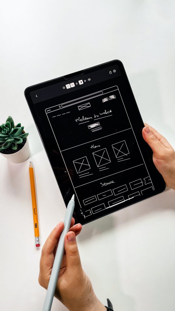 An interaction designer sketching out a wireframe on a tablet computer. 